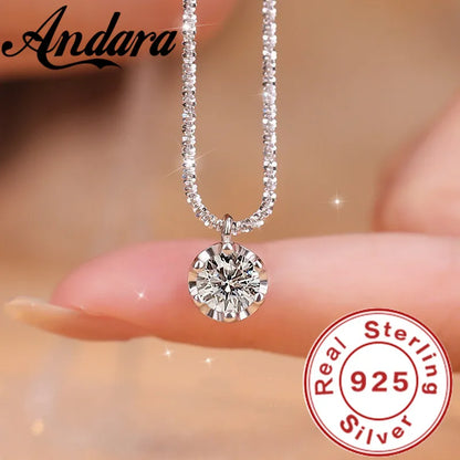 Silver necklace with a round pendant held by fingers, Andara brand visible, 'Real Sterling 925' stamp.