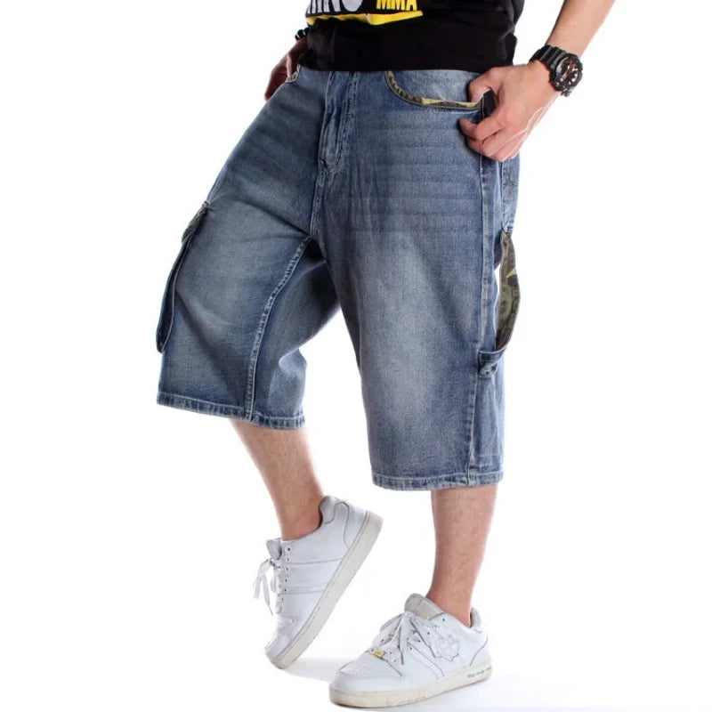 Person wearing blue denim shorts and white sneakers on a white background