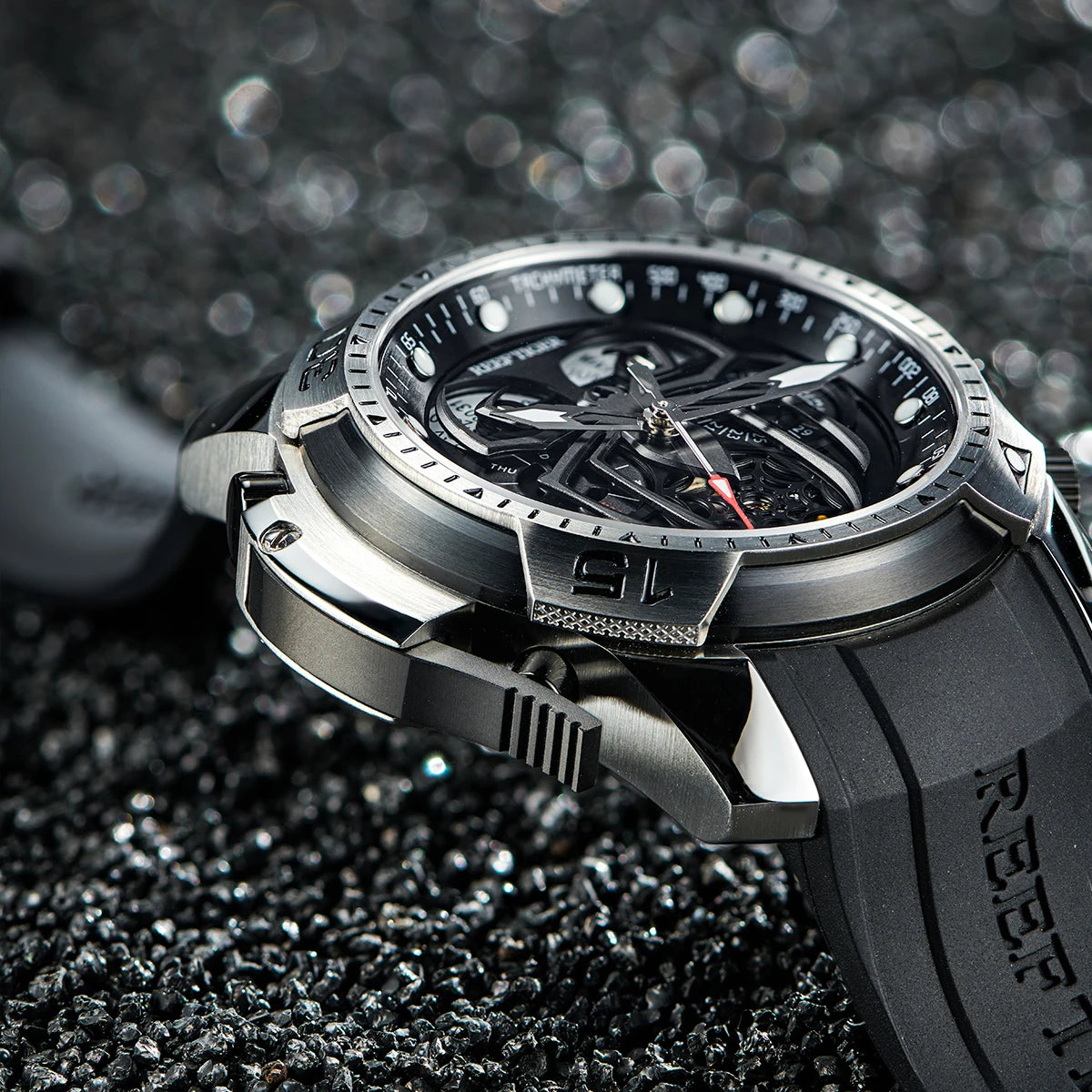 Silver and black watch with detailed design on a textured black surface