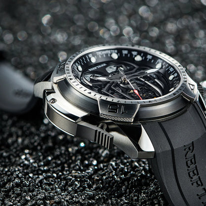 Silver and black watch with detailed design on a textured black surface
