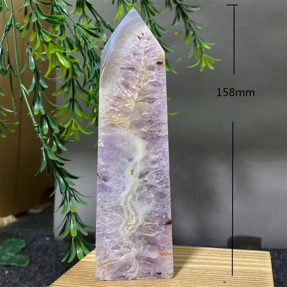 Amethyst crystal tower with greenery on a wooden stand