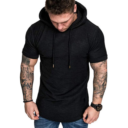 Man wearing a black hoodie with tattoos on arms against a white background