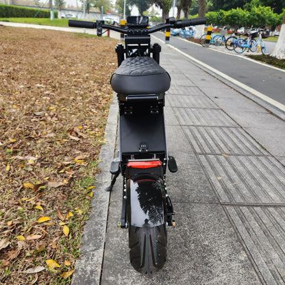 Black electric scooter on a sidewalk with a road and parked bicycles in the background