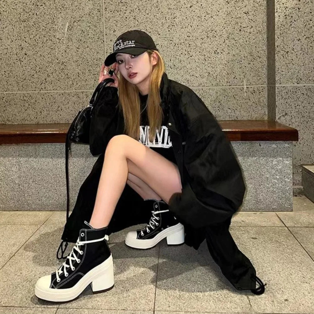 Person wearing black high-top sneakers sitting on a bench.