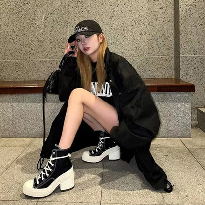 Person wearing black high-top sneakers sitting on a bench.