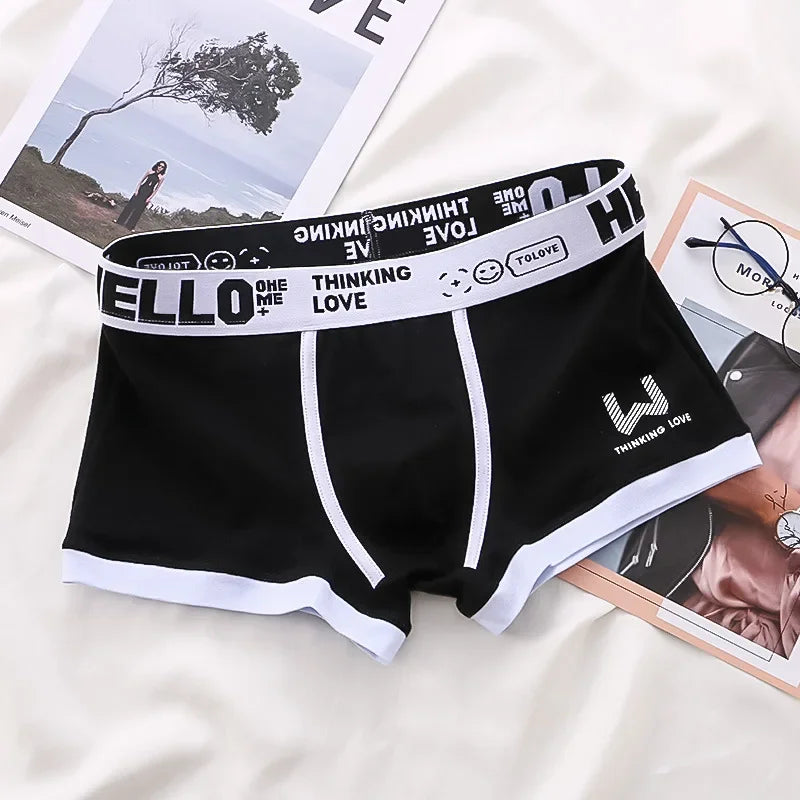 Black boxer briefs with a white logo and text on a magazine background