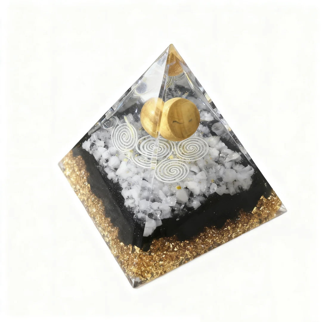Pyramid-shaped decorative item with gold and white elements on a white background