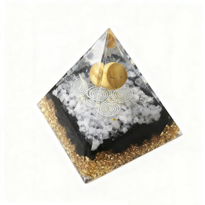 Pyramid-shaped decorative item with gold and white elements on a white background