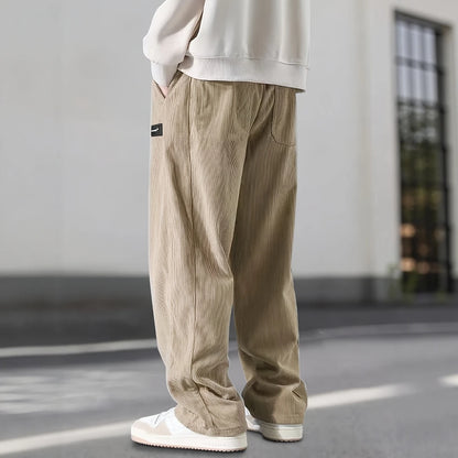 Person wearing beige corduroy pants and white shoes on a blurred background