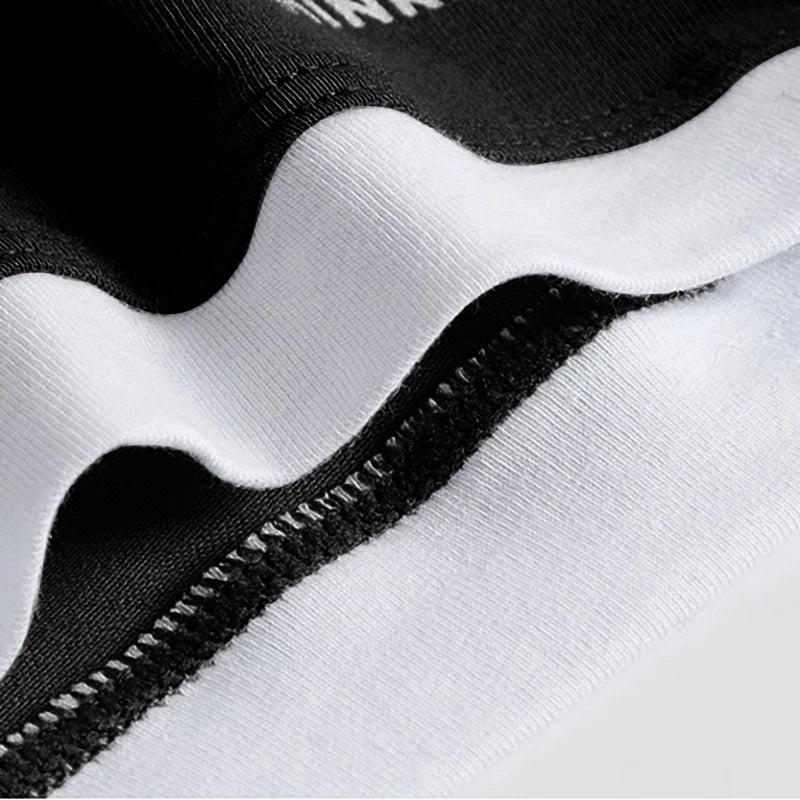 Close-up of a black and white textured fabric with a zipper detail.