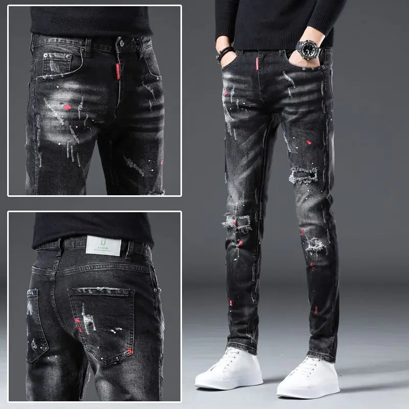 Black distressed jeans with red accents worn by a person on a gray background