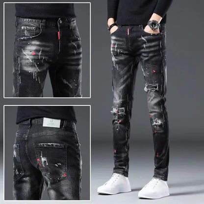 Black distressed jeans with red accents worn by a person on a gray background