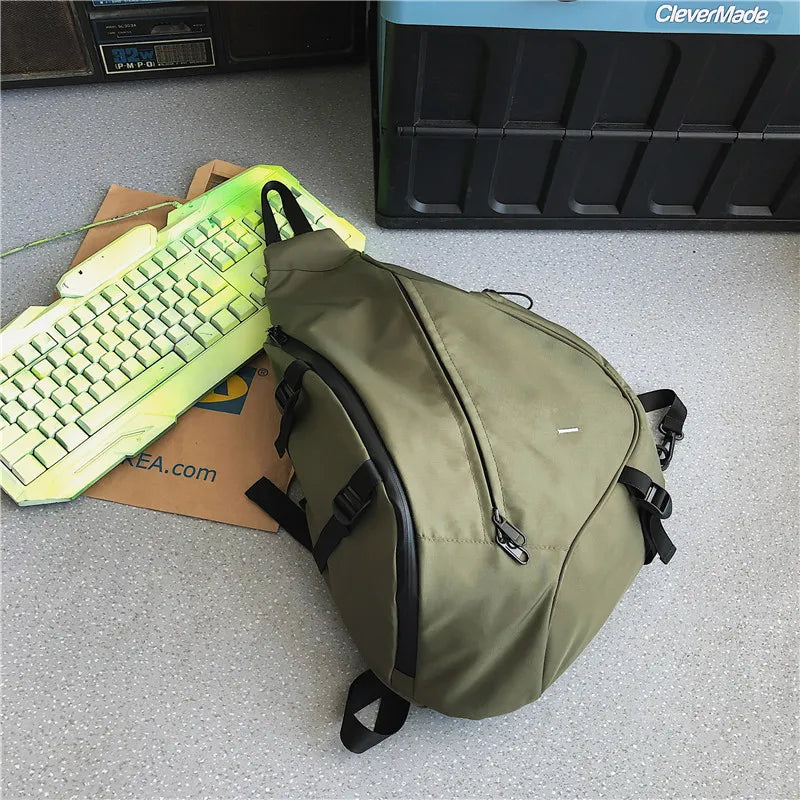 Green backpack on a gray floor with a keyboard and CleverMade box in the background.