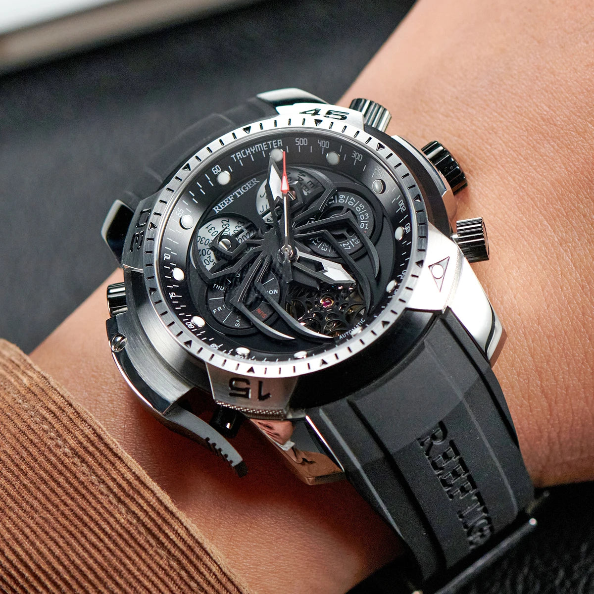Luxury watch with black strap and detailed face on a wrist.