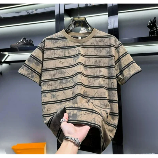Striped t-shirt on a hanger with a hand holding it, against a blurred indoor background.