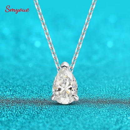 Teardrop-shaped diamond pendant on a chain against a turquoise background
