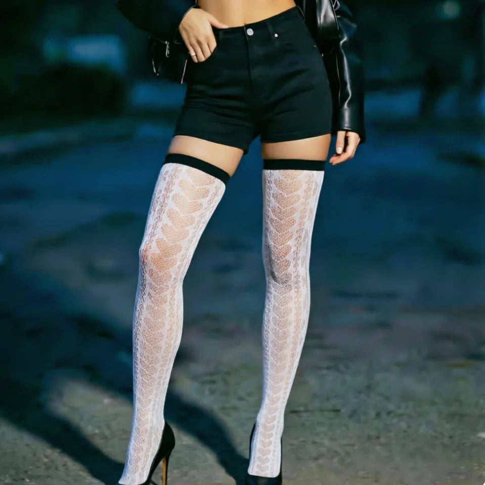 Person wearing white lace thigh-high stockings with black accents on a blurred background