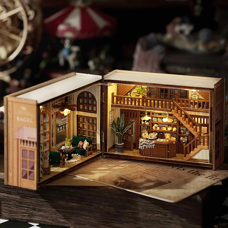 Open model of a miniature book with a detailed interior scene, resembling a cozy cafe or library.