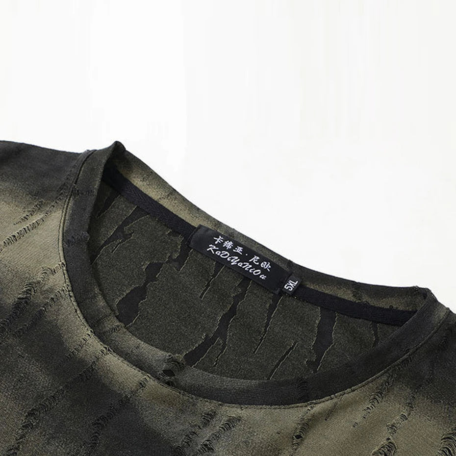 Close-up of a dark green t-shirt with a brand label on a white background