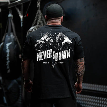 Person wearing a black t-shirt with 'Never Back Down' text and mountain graphic, standing in a dark room.