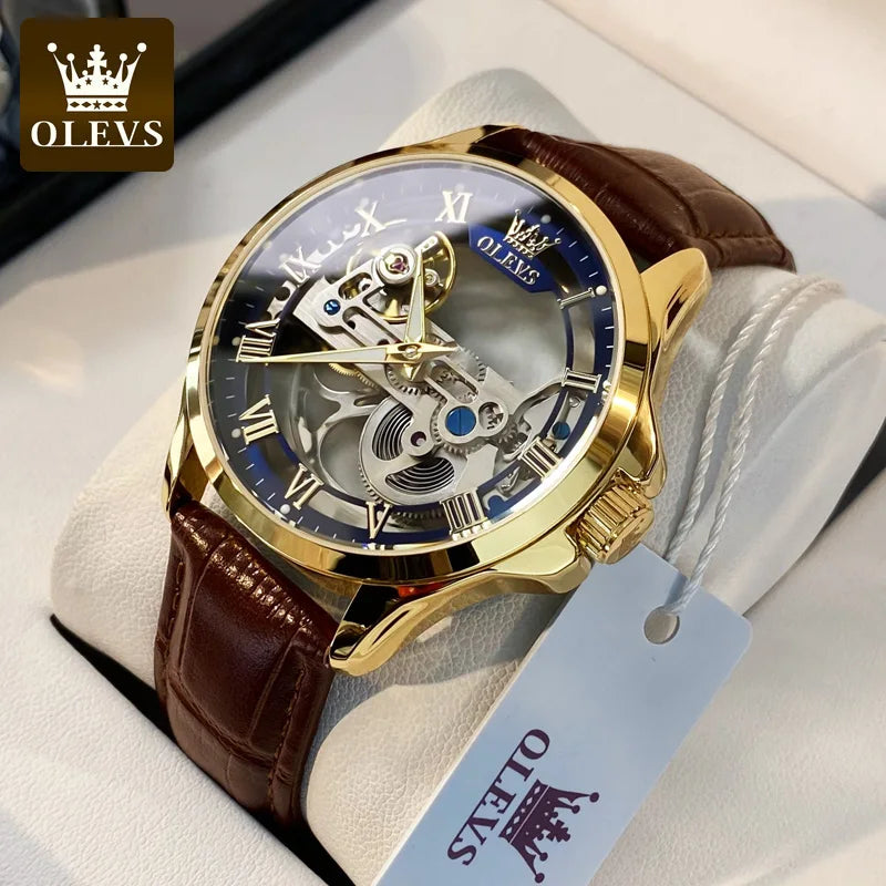Gold watch with brown leather strap on a white cushion, branded 'OLEVS'.