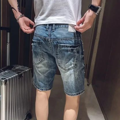 Person wearing blue denim shorts with a suitcase in the background