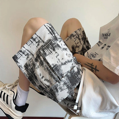 Person sitting with a black and white patterned bag and a white shirt with text.