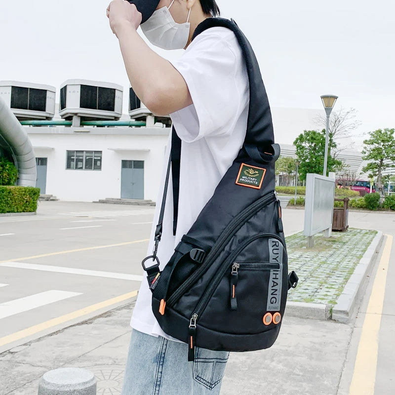 Person wearing a black sling bag with visible branding in an outdoor setting