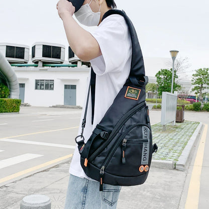 Person wearing a black sling bag with visible branding in an outdoor setting