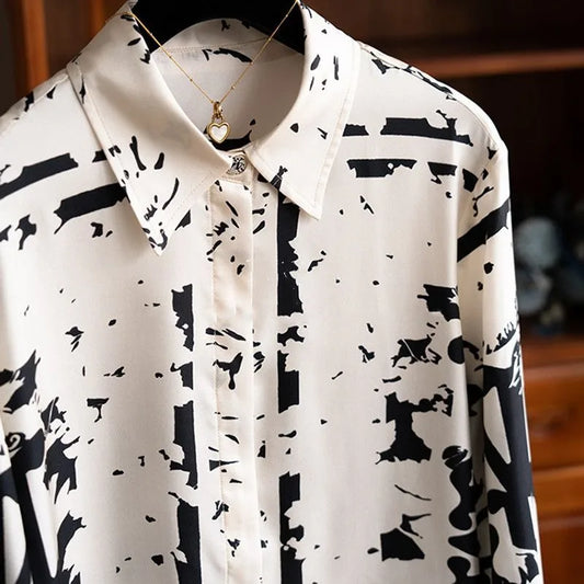 White shirt with black abstract pattern on a wooden surface