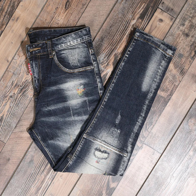 Pair of distressed blue jeans on a wooden floor