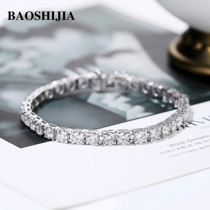 Silver bracelet with clear stones on a magazine page, featuring the brand 'BAOSHIJIA'.
