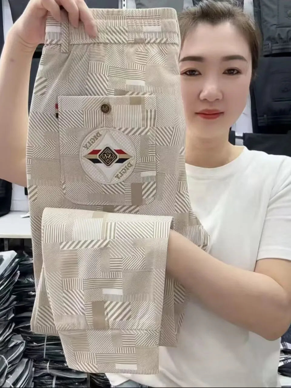 Person holding a patterned fabric swatch with a brand logo.
