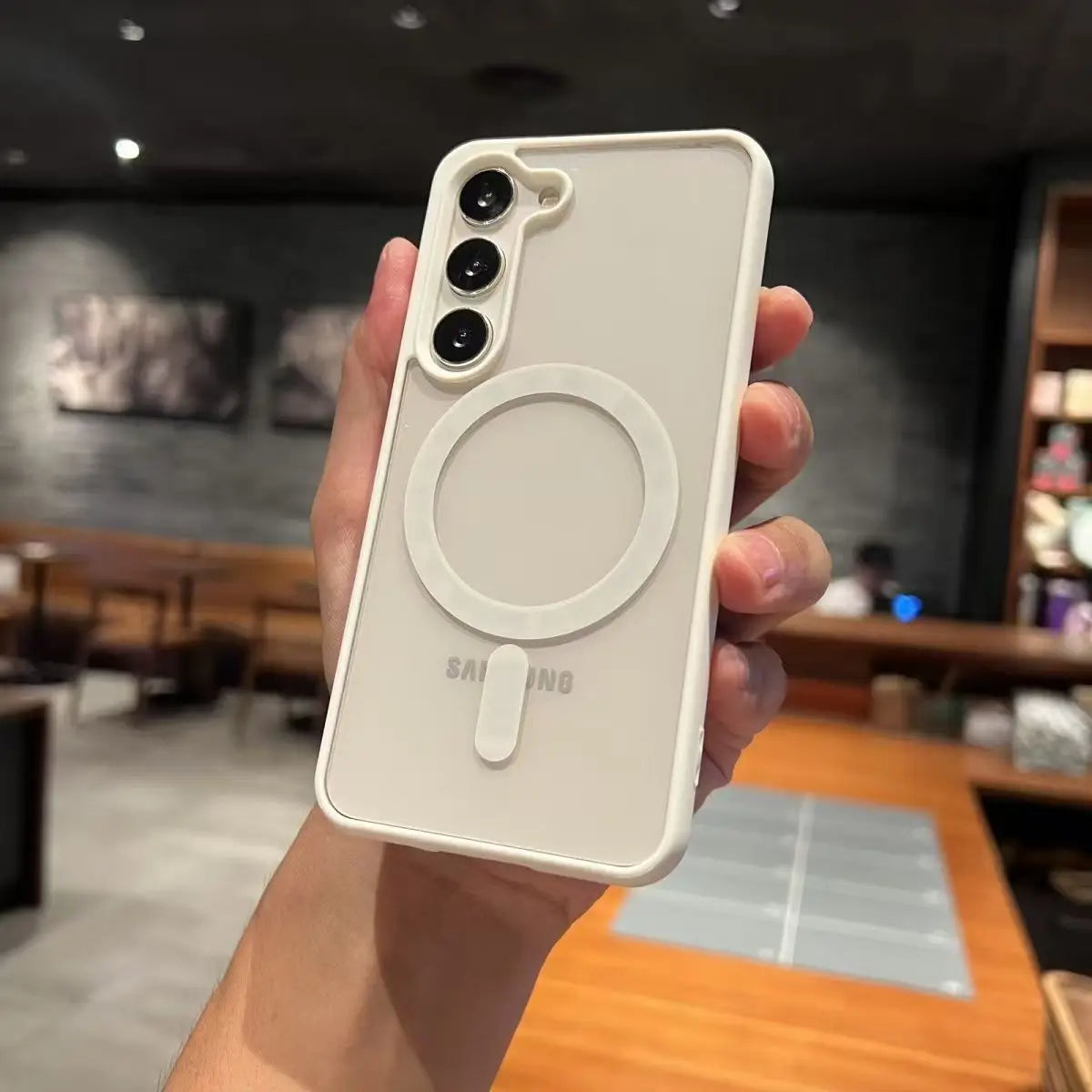 Hand holding a Samsung phone case with a blurred indoor background