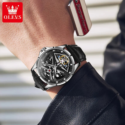 Close-up of a person wearing a black and silver watch with a blurred background
