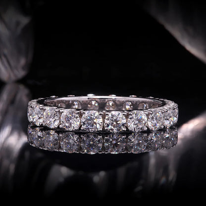 Diamond eternity ring on a reflective surface with a dark background