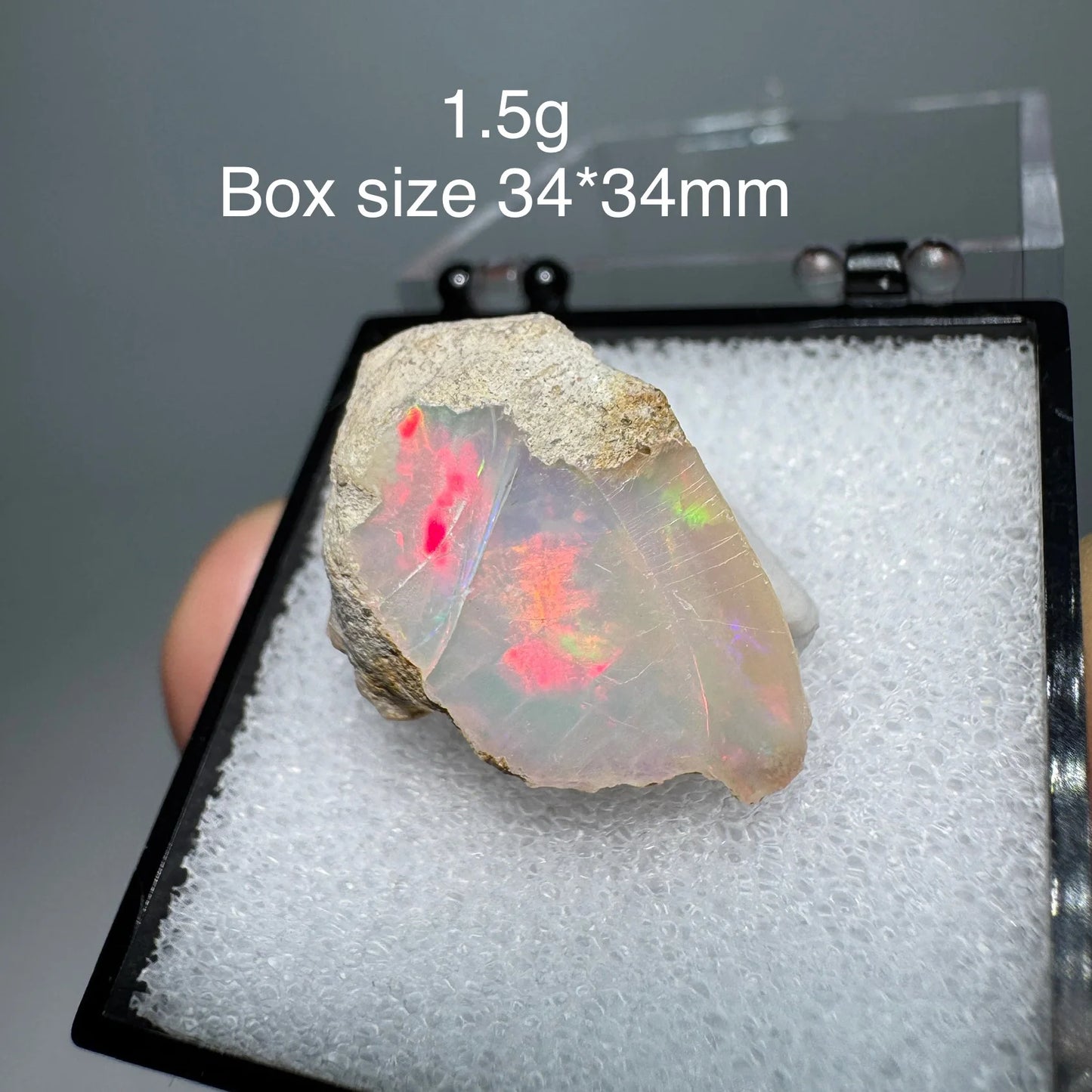 Opal stone in a display case with size and weight information.