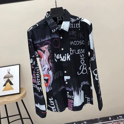 Black shirt with graphic designs and text on a hanger against a beige wall.