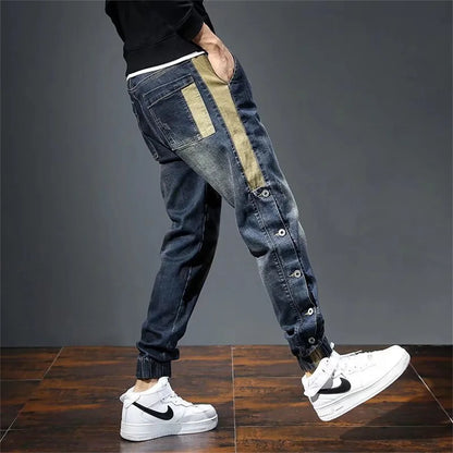 Person wearing blue jeans with a green stripe and white sneakers on a dark gray background