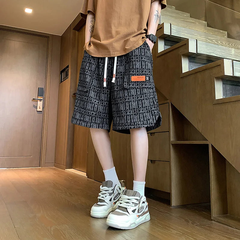 Person wearing a brown shirt, patterned shorts, and white sneakers in a room with wooden flooring and furniture.