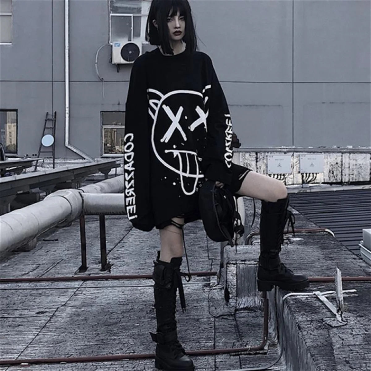 Person wearing a black sweater with white graphics on a rooftop.