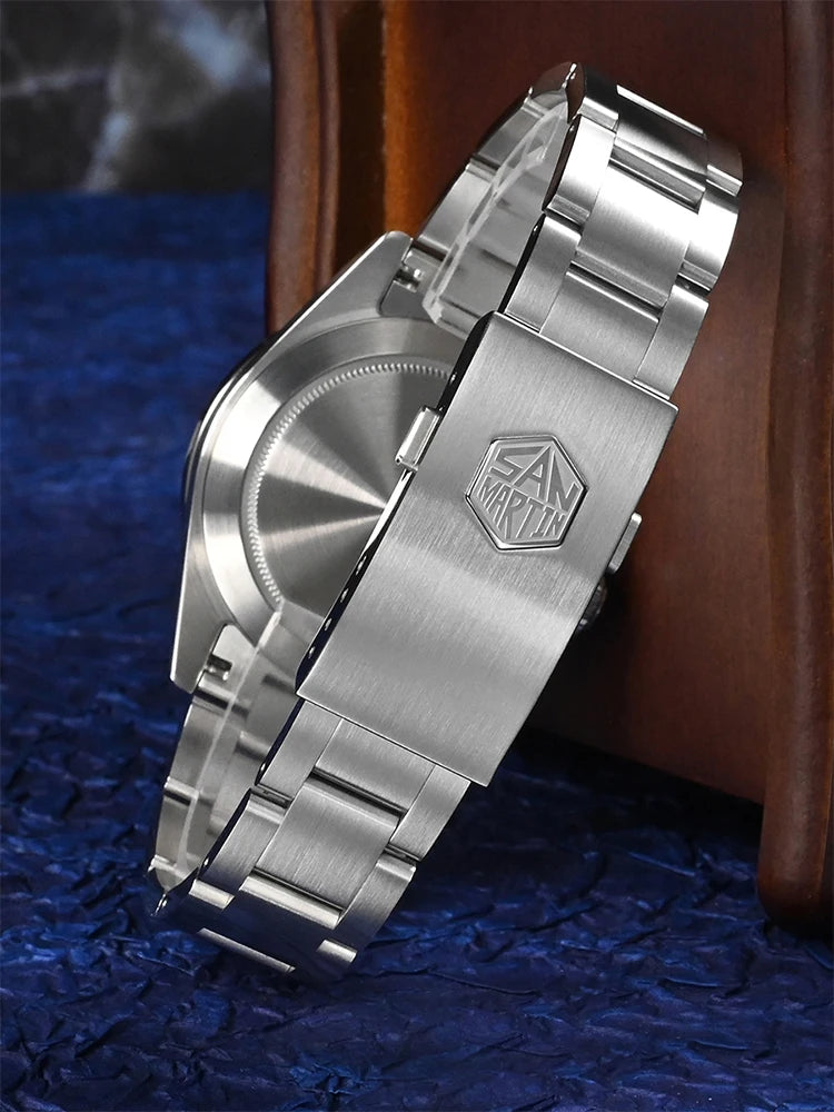 Silver watch with a brand logo on a textured blue surface