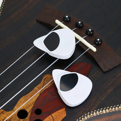 White guitar picks on a wooden guitar neck