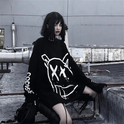 Person wearing a black sweater with white graphics in an urban setting