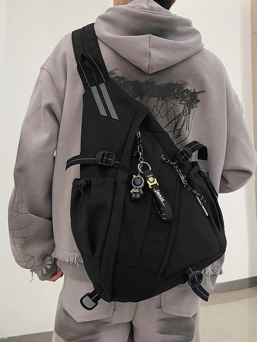 Person wearing a black backpack with a gray hoodie and pants indoors.