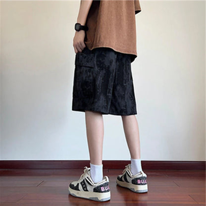 Person wearing black shorts and white sneakers in a minimal indoor setting