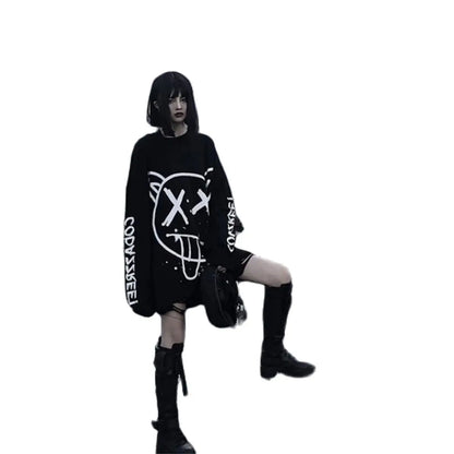 Person wearing a black oversized sweater with white designs on a white background