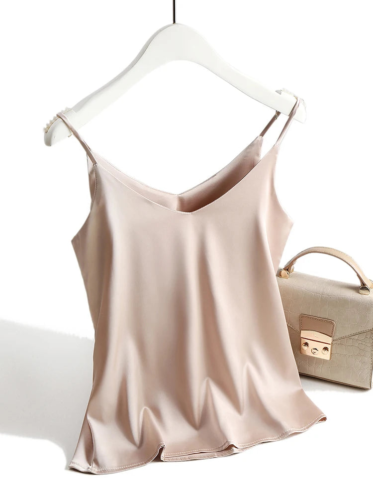 Beige satin camisole on a hanger with a beige handbag in the background