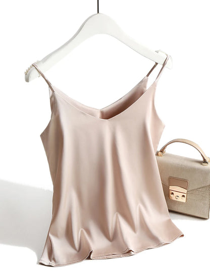 Beige satin camisole on a hanger with a beige handbag in the background