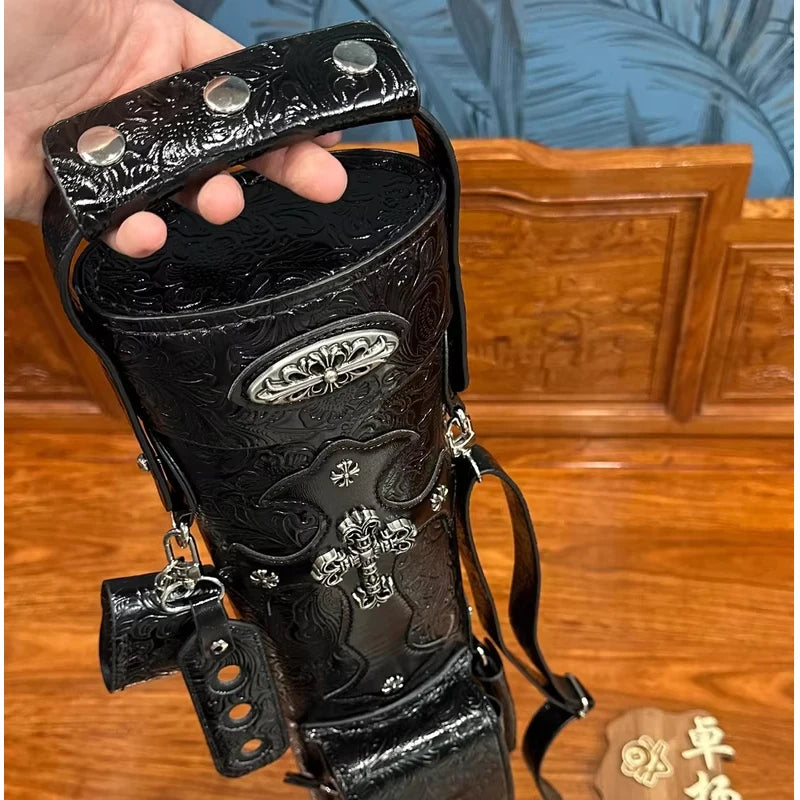 Black leather glove with silver studs and designs on a wooden surface